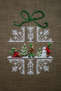 a cross stitch christmas tree with presents on it