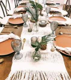 the table is set with plates and place settings