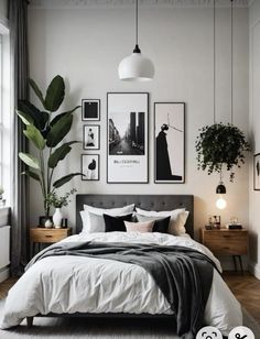 a bedroom with white walls and pictures on the wall above the bed, along with potted plants