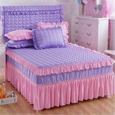 a bed with pink and purple ruffles on it