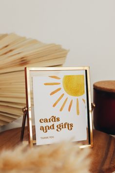 a card and gift box sitting on top of a wooden table next to a candle