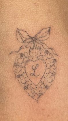 a tattoo on the back of a woman's stomach with a heart and bow