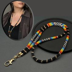 Indulge in the charm of our Rainbow Seed Bead Lanyard. It's not just an accessory; it's a thoughtful gift for teachers and an elegant solution for effortless badge wearing. Perfect for busy teachers. Versatile for badges, glasses, or keys. Details and Specifications This accessory is made by hand from vibrant seed beads, intricately arranged in an ethnic-style pattern. Can be utilized as a badge lanyard featuring a big lobster clasp and as an eyeglass holder with silicone loop connectors. Size T Diy Lanyard, Chain Lanyard, Badge Lanyard, Teacher Lanyard, Beaded Lanyards, Eyeglass Holder, Rainbow Beads, Rainbow Design, Badge Holders