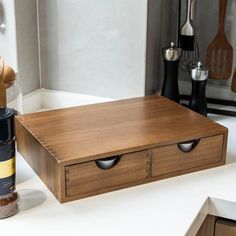 a kitchen counter with spices and utensils on it, including an empty spice box