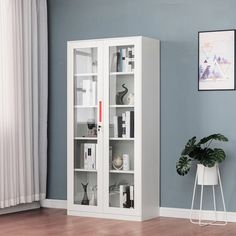 a tall white bookcase with glass doors in a living room next to a potted plant