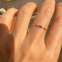 a woman's hand with a ring on it, and an orange object in the background