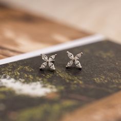 Perfectly floral and dainty, our Marquise Diamond Flower Studs make for a delicate and understated addition to your wedding look. Whether you are a bride, bridesmaid or guest, wear these flower-inspired earrings for a pop of summer. SKU: RR-ER491 Product Details Material: High Quality Solid 925 Sterling Silver Finish: Sterling Silver ∙ 18K Gold Featuring ~10x10mm Marquise Flower Studs with four ~4x2mm CZ Diamond Petals Sold as a Pair Featured Styles Part of our Floral Collection Model showcases Marquise Diamond Cut Cluster Earrings For Wedding, Dainty White Diamond Earrings For Wedding, White Diamond Earrings For Wedding Marquise Cut, Wedding Earrings With Marquise Cut And Prong Setting, Dainty Marquise Wedding Earrings, Dainty Silver Diamond Earrings For Wedding, Marquise Cut Earrings With Prong Setting For Wedding, Wedding Marquise Cut Earrings With Prong Setting, Marquise Cut Prong Setting Earrings For Wedding