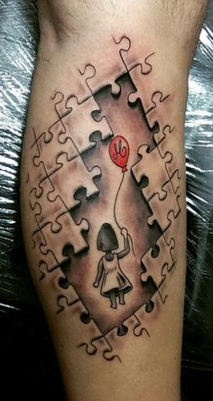 a man with a puzzle piece tattoo on his leg holding a red balloon in the shape of a heart