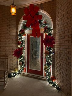 a red door decorated with christmas decorations and lights