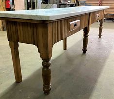 a wooden table with marble top in a shop