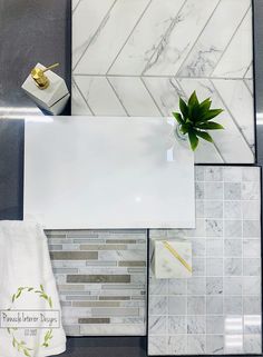 a bathroom counter with white marble tiles and a green plant in a glass vase on top