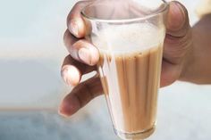 a person holding a glass with liquid in it