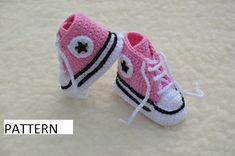 a pair of crocheted pink and white converse shoes with black stars on them