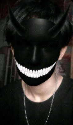 a woman wearing a black mask with white teeth