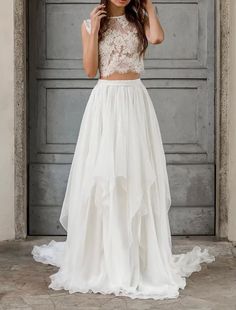 a woman standing in front of a door wearing a white dress