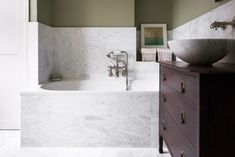 a bathroom with a sink and bathtub next to a mirror on the wall above it