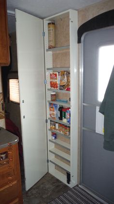 an open pantry in the corner of a kitchen