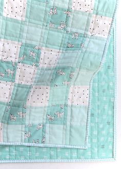 a quilted baby blanket with sheeps on it