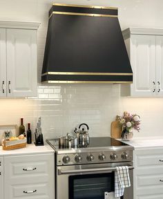 a stove top oven sitting inside of a kitchen next to white cabinets and counter tops