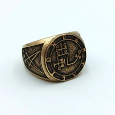 a gold ring with two symbols on it