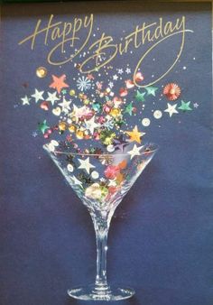 a happy birthday card with a martini glass filled with stars and confetti