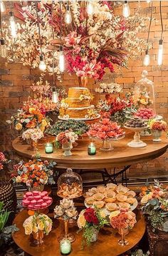 a table topped with lots of different types of cakes and pastries on top of wooden tables