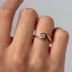 a woman's hand with a diamond ring on top of her finger, showing the side view