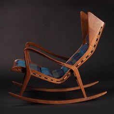 a wooden rocking chair with blue and black plaid seat cushion on it's back