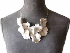 a white flower necklace on a mannequin