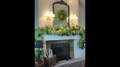 the fireplace is decorated with greenery and candles