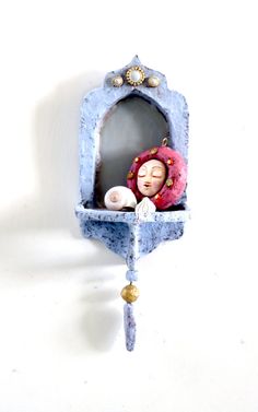 a blue clock with a doll in it