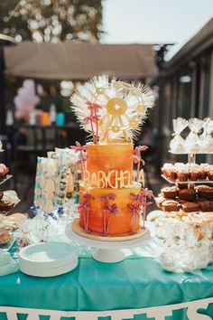 an orange cake sitting on top of a table next to other desserts and pastries