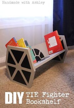 a book shelf made out of cardboard with books on it and the words diy tie fighter bookshelf