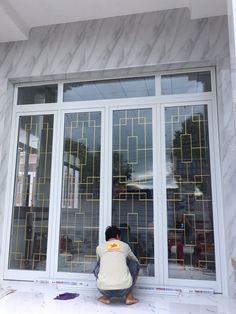 a person kneeling down in front of a window