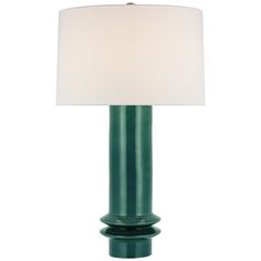 a green table lamp with a white shade on the top and bottom part of it