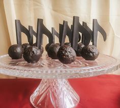 chocolate truffles on a clear cake plate with black candles and numbers in the middle