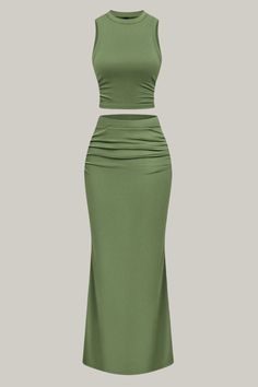 a woman wearing a green skirt and cropped top with one side slited out