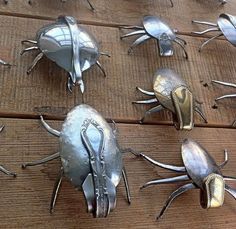 several metal bugs sitting on top of a wooden floor