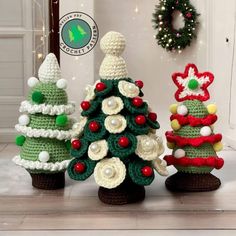 three crocheted christmas trees sitting next to each other