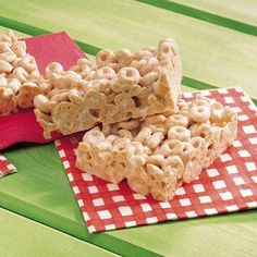 three pieces of cereal bar sitting on top of a red and white checkered napkin