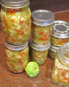 several jars filled with pickles sitting on top of a counter