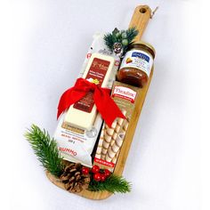 an assortment of food and condiments in a wooden tray on a white surface