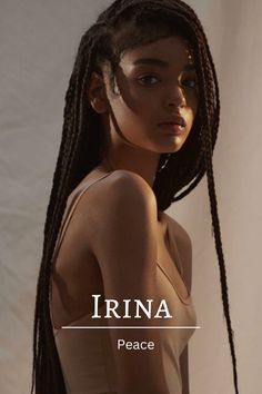 a woman with long braids standing in front of a white backdrop