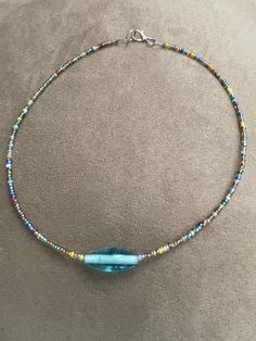 a blue beaded necklace on a beige surface