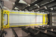 the inside of a building with metal shelves and yellow bars on each side, along with other equipment