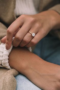 a close up of a person wearing a ring on their arm and holding the other hand