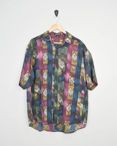 90s print shirt by Structure. Fantastic print. Listed as a size Large. Pocket on the chest. Great vintage condition. Please see detailed measurements below as vintage sizes can sometimes run small and fit preferences and body types vary. Spend $35 or more in the U.S. to get free shipping. To see more 90s items, click on the link below: www.etsy.com/shop/JusticeAndFreedom?ref=hdr_shop_menu&search_query=90s ✂-----Measurements Chest (armpit to armpit): 25 inches Length Front: 29 inches Length Back: Multicolor Graphic Print Button-up Short Sleeve Shirt, Multicolor Printed Button-up Camp Shirt, Patterned Graphic Print Button-up Camp Shirt, Multicolor Graphic Print Button-up Camp Shirt, Patterned Camp Collar Shirt With Graphic Print, Retro Patterned Printed Shirt, Patterned Collared Hawaiian Shirt With All Over Print, Multicolor Collared Shirt With All Over Print, Retro Multicolor Camp Shirt With All Over Print