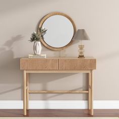 a table with a mirror, lamp and vase on it in front of a wall