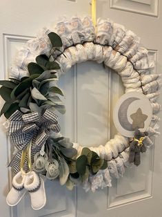 a wreath made out of diapers and baby booties hanging on the front door