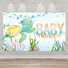 an ocean themed baby shower sign hanging on the wall in a room with wood flooring